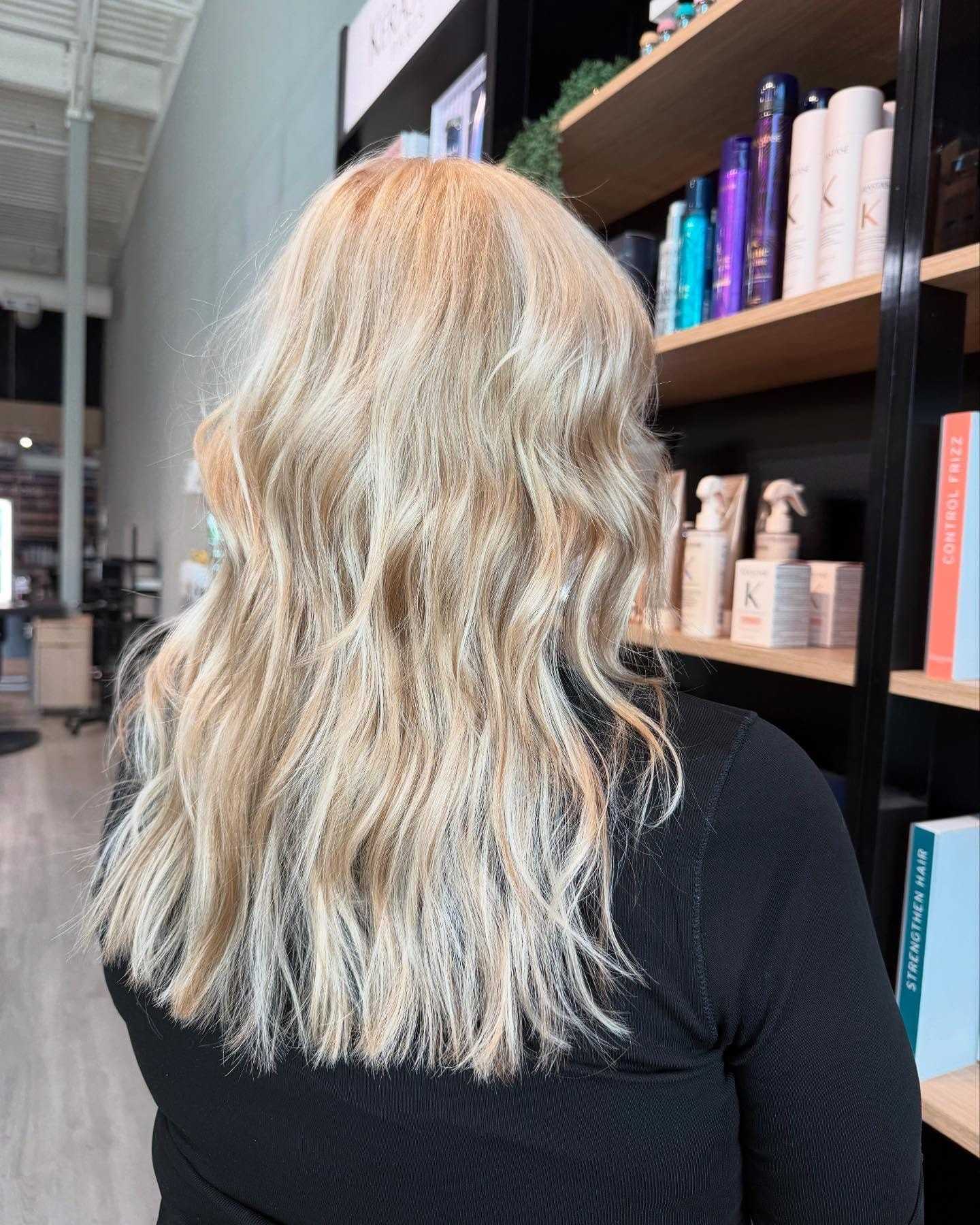 Blonde hair with soft waves in a modern salon setting.