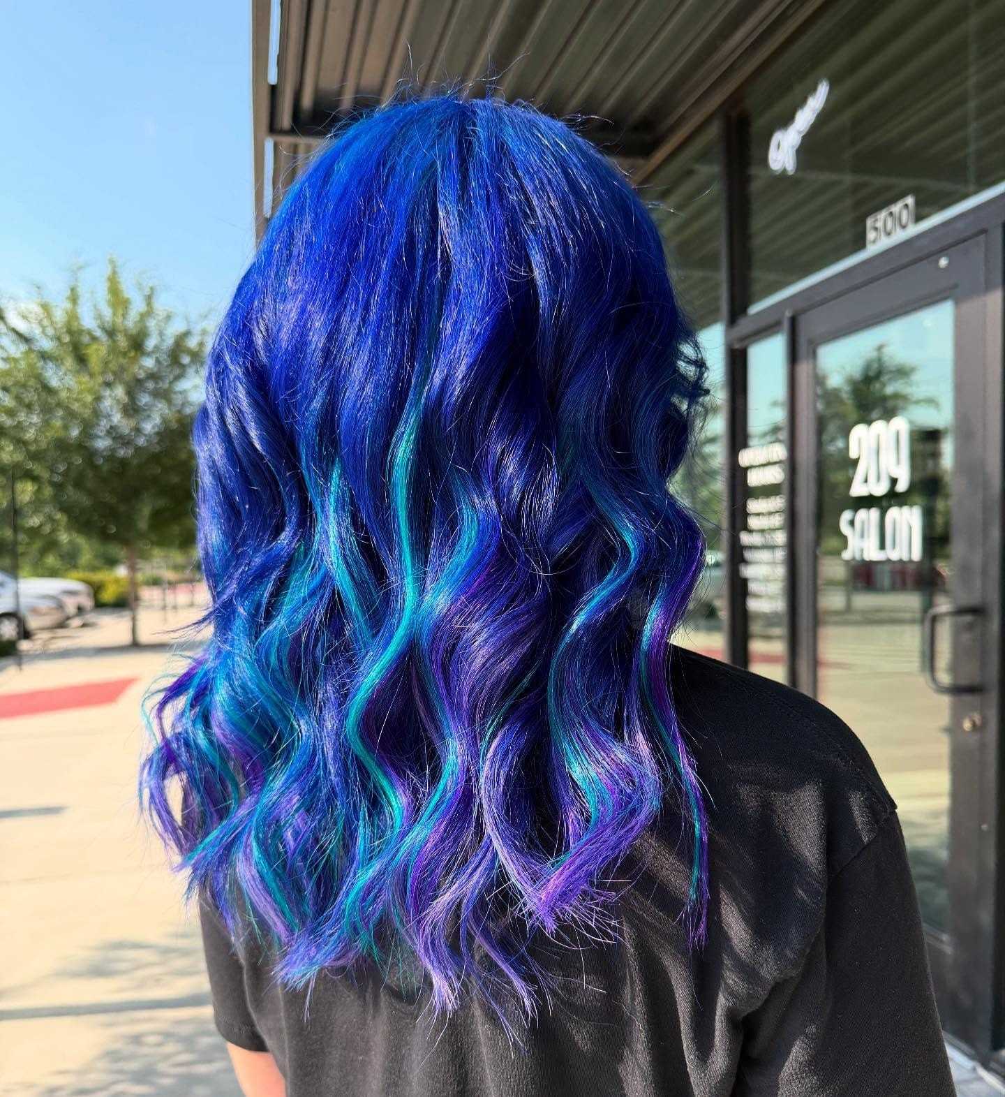 Blue and teal wavy hair outside a salon.
